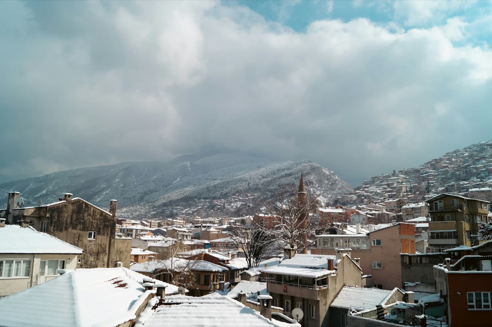 بورصة شتاءً: أسطح مغطاة بالثلج والجبل في الخلف
